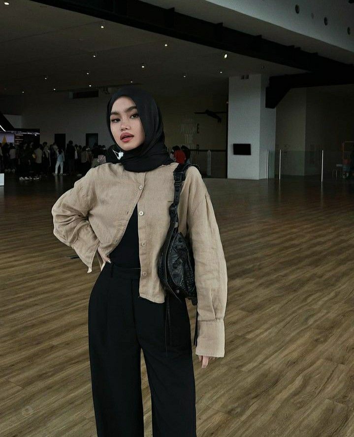 a woman standing on a hard wood floor with a handbag in her other hand