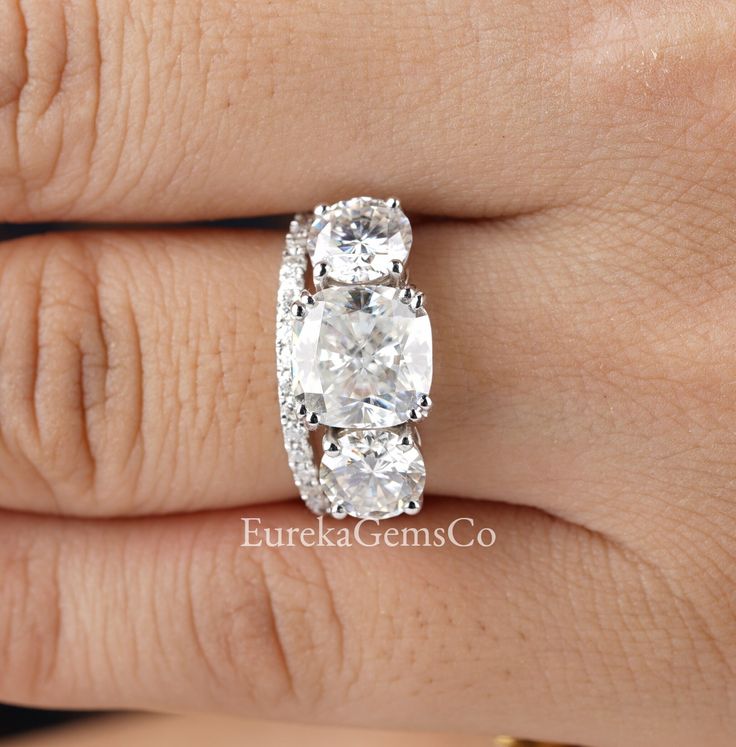 a woman's hand with a diamond ring on her left hand and the center stone is