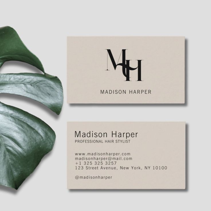 a business card with a green leaf on it and the words madison harper written in black