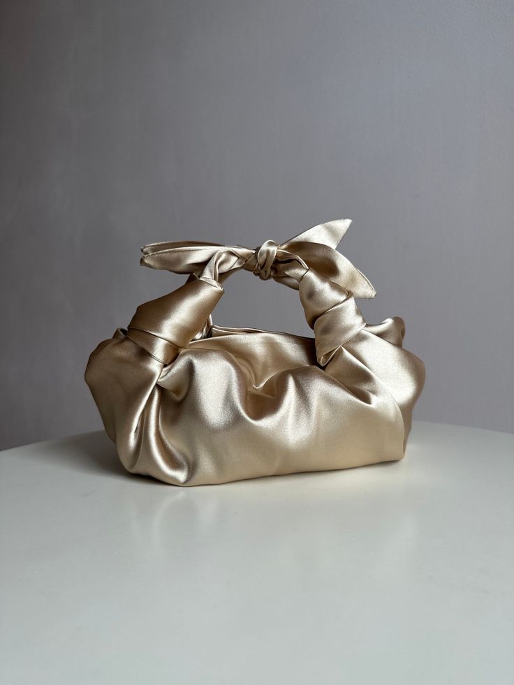 Champagne satin bag with knots. Stylish small handmade bag that is suitable for any event. Bag with bows is soft, closes with a magnetic button. This knotted bag is made in a vintage style based on the Japanese technique of tying a silk women's scarf into a handbag. Elegant woman light gold bag is very roomy - fits a phone, wallet, keys, makeup. Perfect wedding purse. The handbag can be sewn from satin or velvet. I have a huge selection of colors, more than indicated in the listing. Please write Satin Purses, Japanese Knot Bag, Big Handbags, Knot Bag, Woman Handbag, Japanese Bag, Colors Wedding, Wedding Purse, Satin Bags