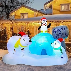 an inflatable polar bear and penguin with north pole sign