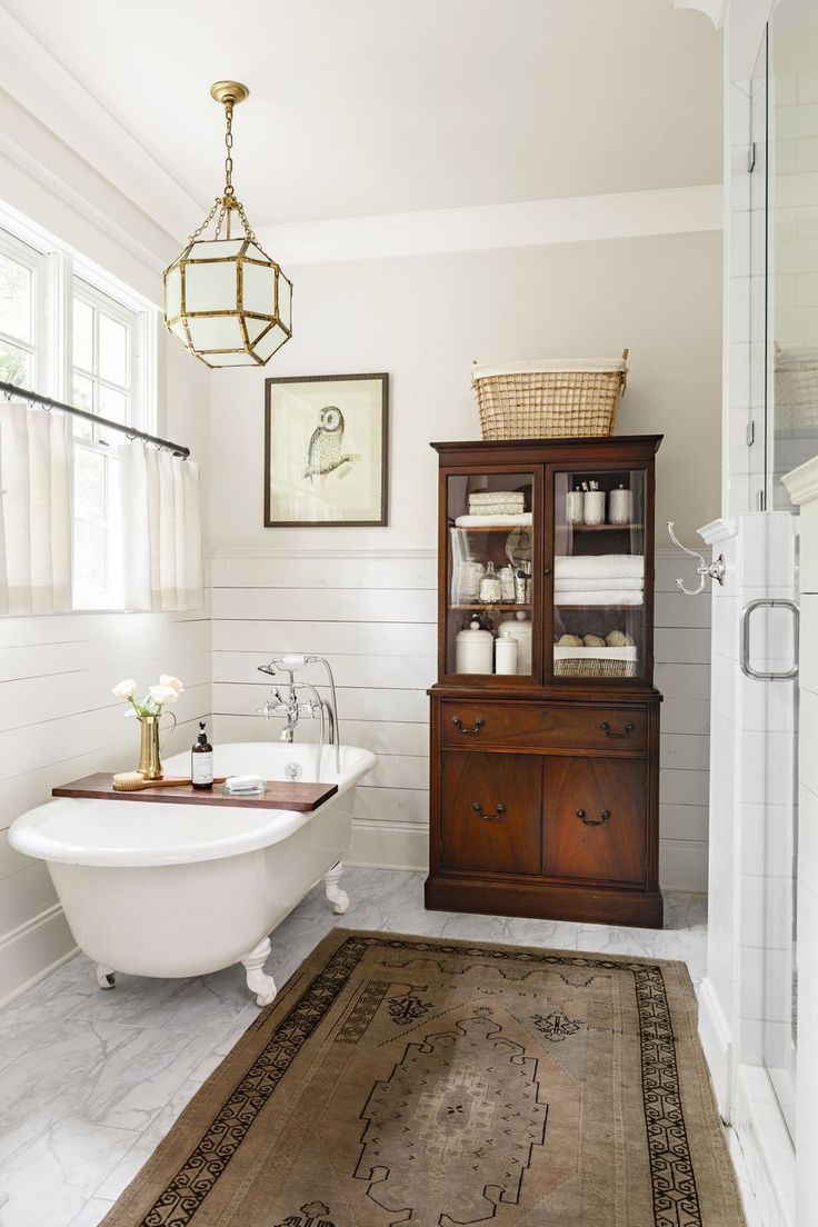 a white bath tub sitting next to a wooden cabinet