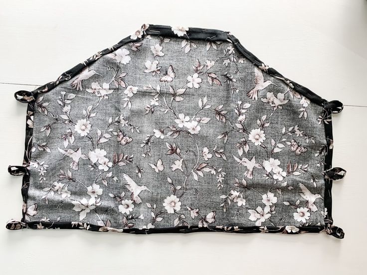 a black and white flowered apron hanging on the wall