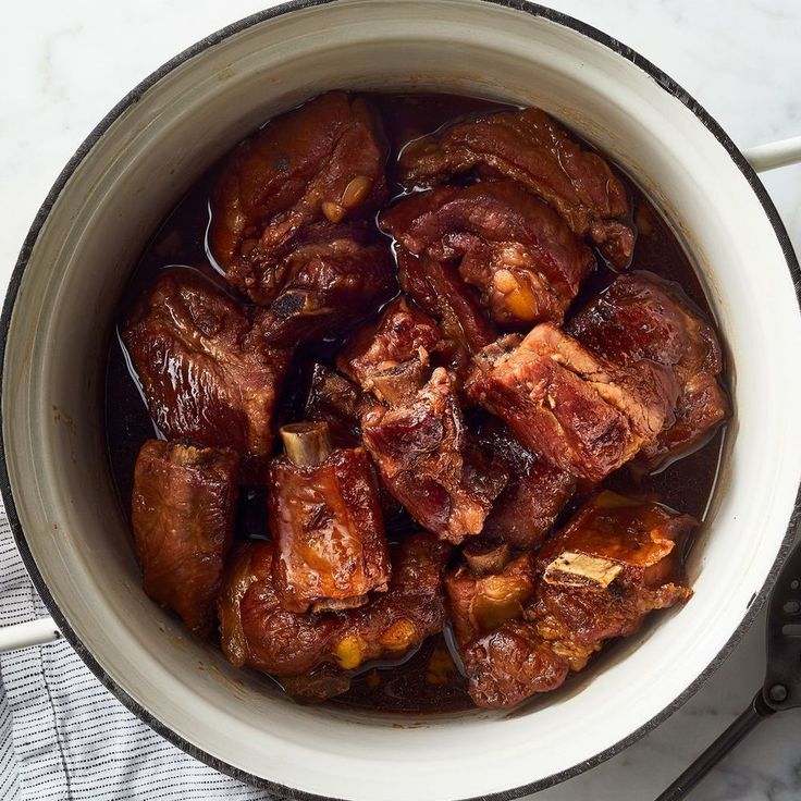 a bowl filled with meat sitting on top of a table