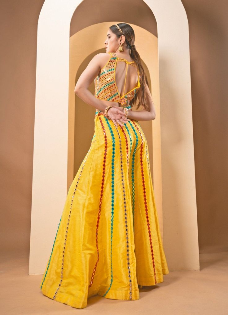 Featuring an exquisite yellow multicolour raw silk blouse, adorned with intricate resham work and sparkling mirror embellishments. Paired seamlessly with a matching raw silk sharara, this ensemble epitomizes sophistication. Add the finishing touch with a soft net dupatta featuring detailed resham work and mirror accents. Ideal choice for adding a luxurious touch to Mehendi or Haldi outfit. Composition : Blouse, Sharara - Raw Silk, Dupatta - Soft Net Care: Dry Clean Only and Vacuum Storage This p Festive Multicolor Palazzo Set For Party, Multicolor Zari Work Palazzo Set For Party, Multicolor Anarkali Palazzo Set For Party, Fitted Yellow Palazzo Set For Party, Yellow Fitted Palazzo Set For Party, Multicolor Chanderi Sharara With Dori Work, Multicolor Chanderi Palazzo Set For Party, Yellow Resham Embroidery Palazzo Set For Navratri, Yellow Chanderi Palazzo Set For Party