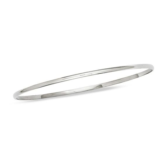 A timeless classic, this sleek bangle elevates any attire. Crafted in cool 14K white gold, this slender 2.0mm-wide design is a great complement to her other bracelets. Polished to a bright shine, this 7.5-inch bracelet slips on and off with ease. Minimalist Sterling Silver Bangle For Formal Occasions, Classic Stackable Sterling Silver Bracelet, Classic Polished Hoop Bracelets, Classic Hoop Bracelets With Polished Finish, Sleek Polished Bangle Jewelry, Sleek Polished Bangle Bracelet, Classic Flexible Cuff Bracelet For Formal Occasions, Timeless Stackable White Gold Bangle, Minimalist Stackable White Gold Bangle