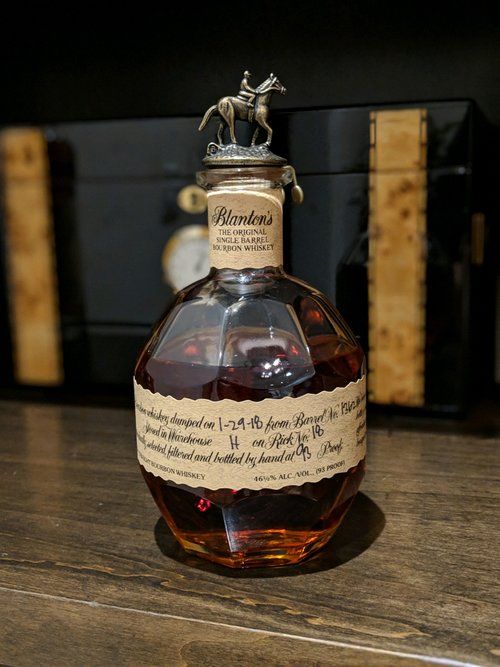 a bottle of brandy sitting on top of a wooden table