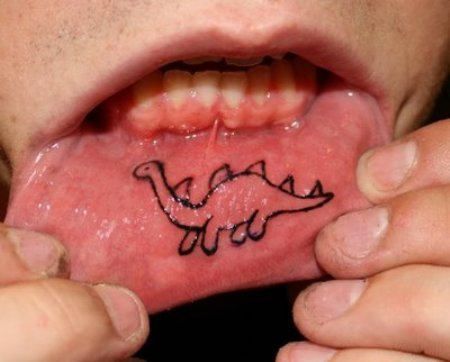 a close up of a person holding a piece of food in their mouth with writing on it