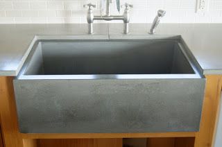 a kitchen sink sitting under a faucet in the middle of a wooden cabinet