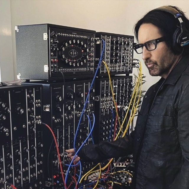 a man wearing headphones standing in front of sound equipment