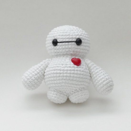 a crocheted white teddy bear with a red heart on its nose and eyes