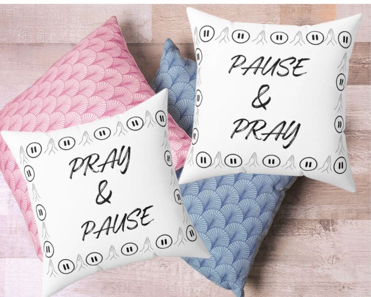 two pillows with words on them sitting on top of a wooden floor next to each other