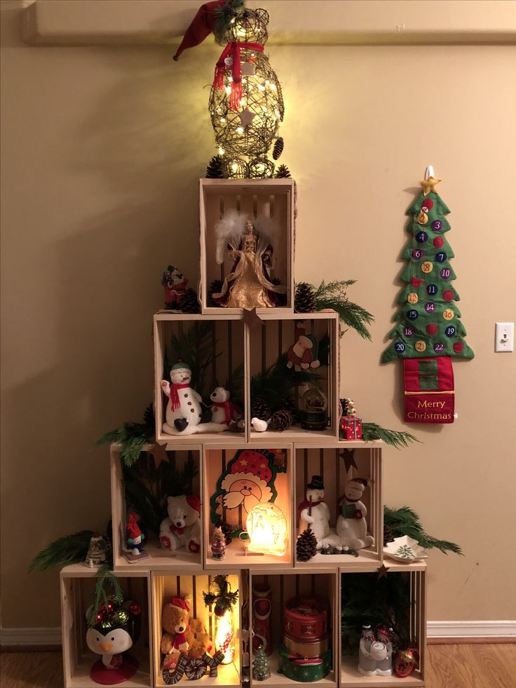 a christmas tree made out of wooden crates with lights on top and decorations around it