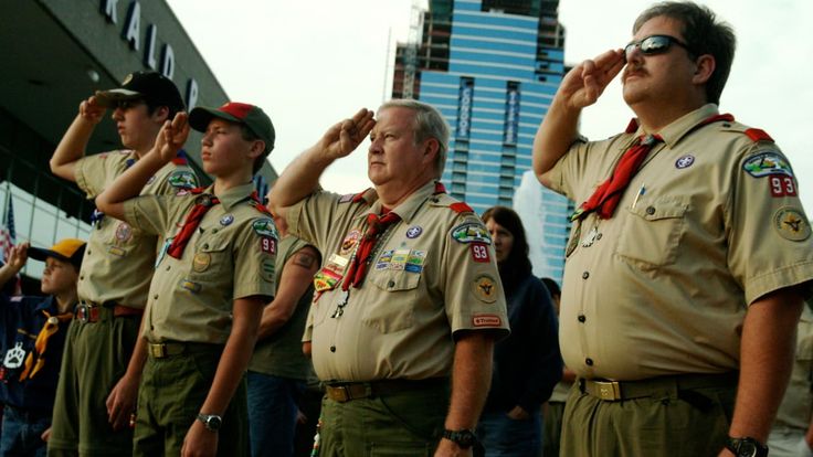 men in uniform saluting while standing next to each other with their hands on their eyes