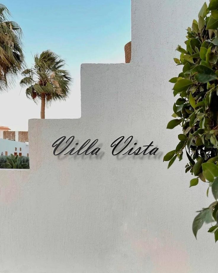 the sign for villa vita in front of palm trees