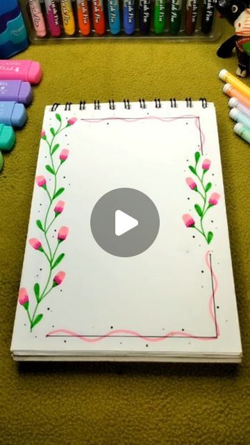 an open notebook sitting on top of a table next to crayons