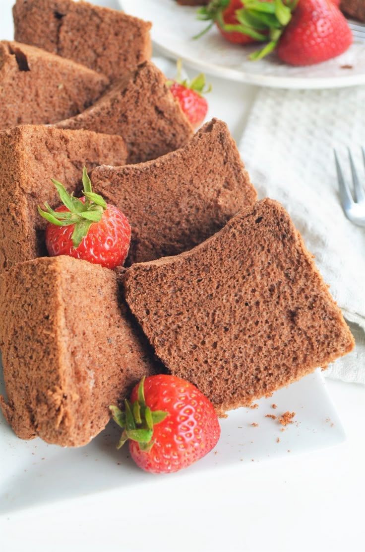 slices of chocolate cake with strawberries on the side