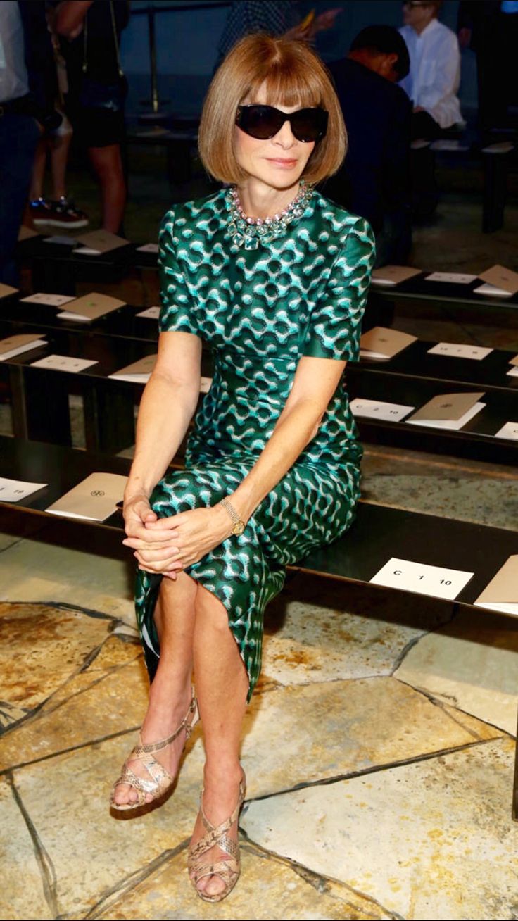 a woman sitting on top of a wooden bench