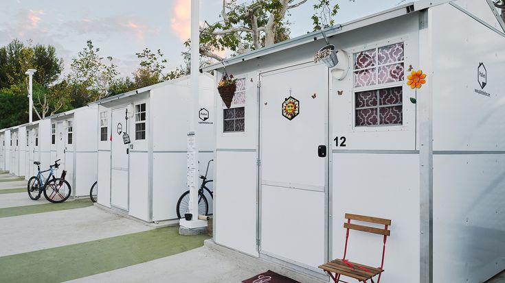 a row of white buildings with bicycles parked outside