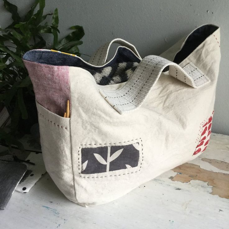 a white bag sitting on top of a table next to a plant