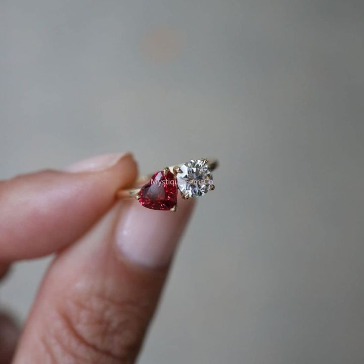 a woman's hand holding an engagement ring with two stones