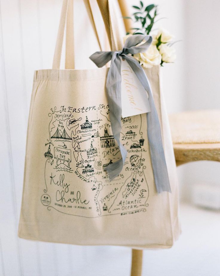 a tote bag hanging from a wooden chair with a ribbon on the handle and map drawn on it