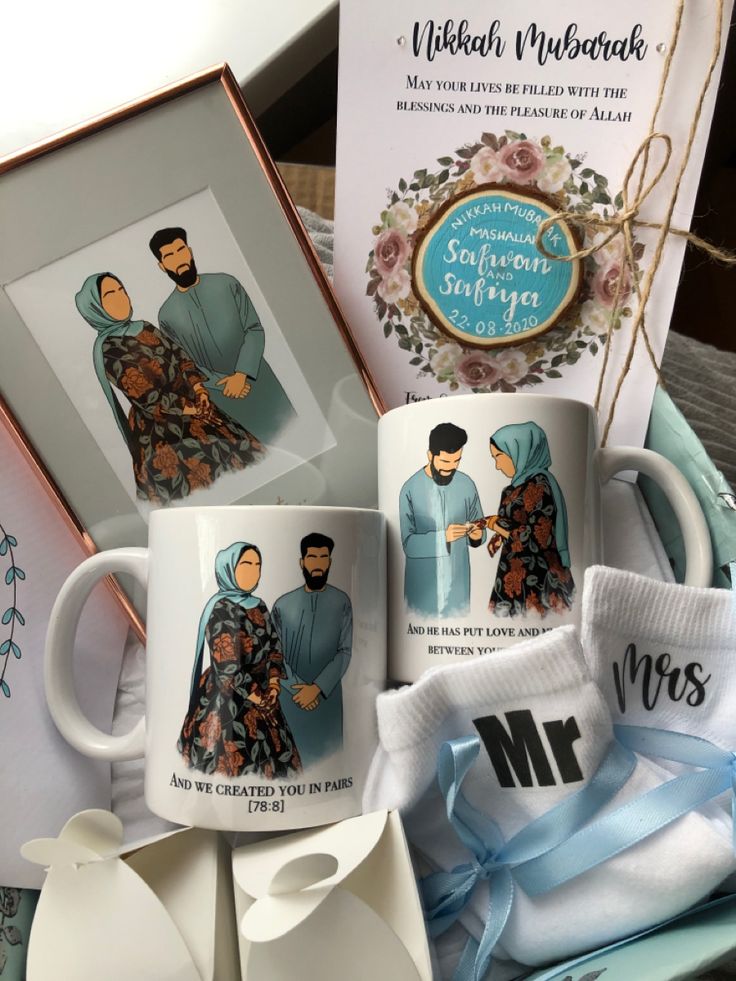 two coffee mugs are sitting next to some greeting cards and a card with the same image on it