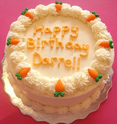 a birthday cake with white frosting and carrots