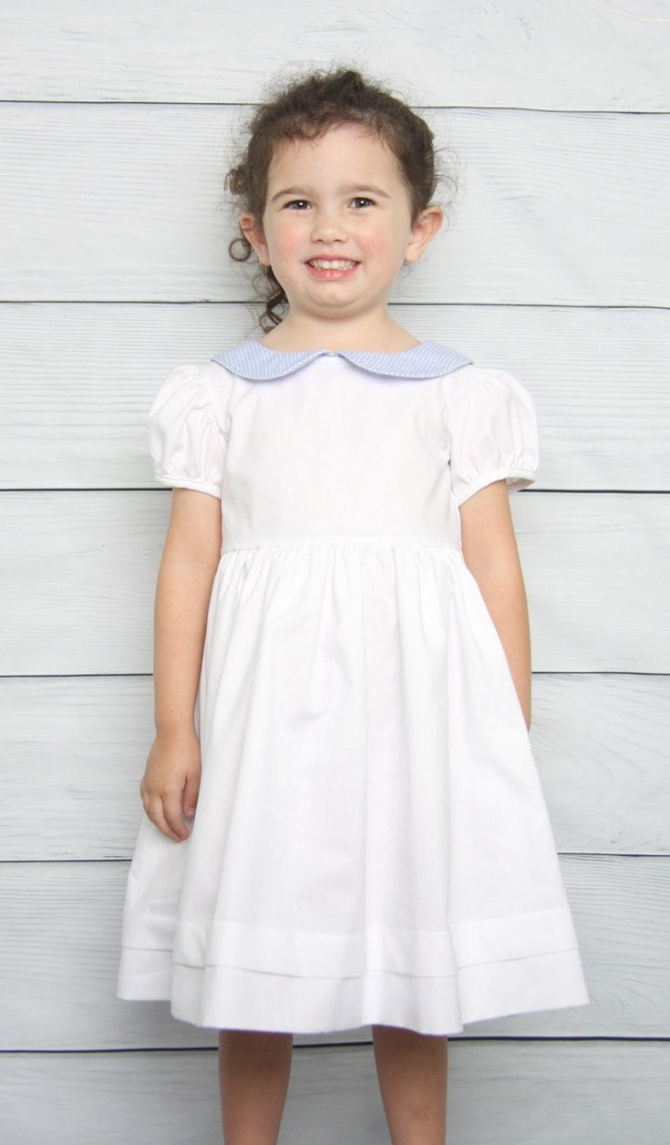 "She will be the center of attention in Easter dresses for girls by Zuli Kids. Toddler Easter dress is white cotton fabric with tuck in skirt with blue gingham peter pan collar. Can come plain or with monogram. Perfect for flower girl dress or toddler girl baptism dress. *Zuli Kids Premium Quality *Peter Pan Collar Shirt *65% cotton 35% Poly *Machine Wash Gentle *Button-Back Closures *Piping in Peter Pan Collar *Puffed Sleeves *Short or Long Sleeves *Available in Size 12 Months - Size 4T *Specia Easter Dresses For Girls, Toddler Easter Dress, Girl Baptism Dress, Girls Baptism Dress, Easter Dresses For Toddlers, Blue Linen Dress, Peter Pan Collar Shirt, Easter Dresses, Girl Baptism