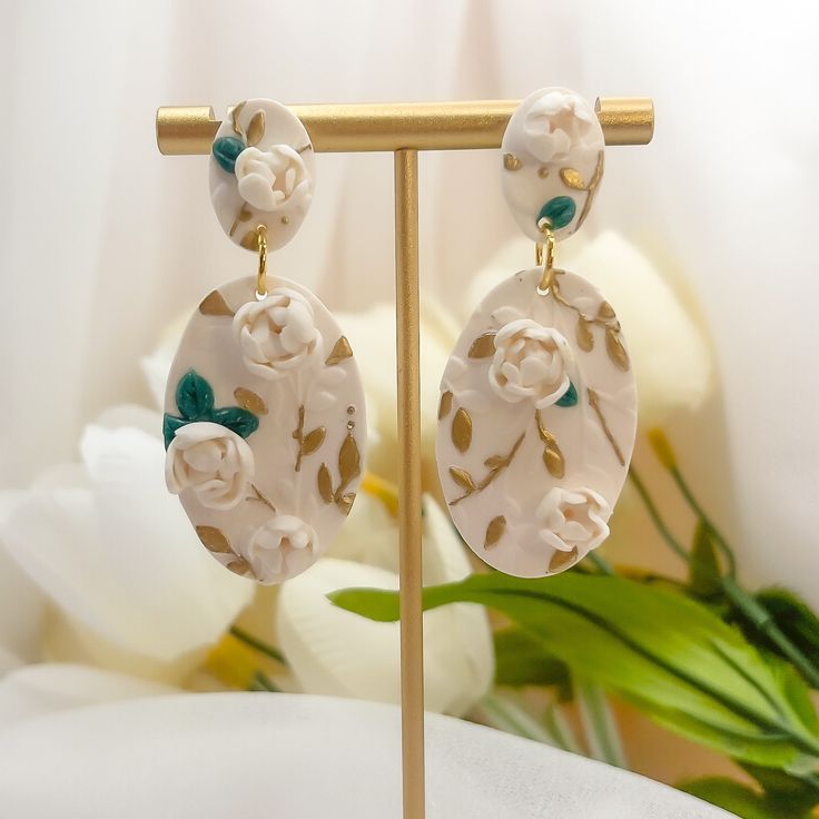 Step into summer with our exquisite Evangeline Earrings, where artistry and elegance bloom. Crafted from polymer clay, each earring showcases intricate 3D floral designs adorned with delicate gold leaf accents, capturing the essence of a summer garden in full bloom. The hypoallergenic gold filled posts ensure comfort for all-day wear, making them perfect for summer outings, weddings, and special events where you want to shine. Gold Jewelry With 3d Flowers In Polymer Clay, Gold Polymer Clay Jewelry With 3d Flowers, Elegant Hand-painted Flower Earrings, Elegant Hand Painted Flower Earrings, Elegant Floral Print Earrings, Handmade Gold Flower Earrings In Polymer Clay, Gold Flower-shaped Polymer Clay Earrings, Handmade Gold Polymer Clay Flower Earrings, Handmade Polymer Clay Flower Earrings In Gold