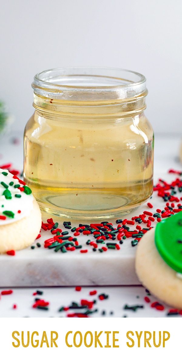 sugar cookie syrup in a jar with sprinkles on the table next to cookies