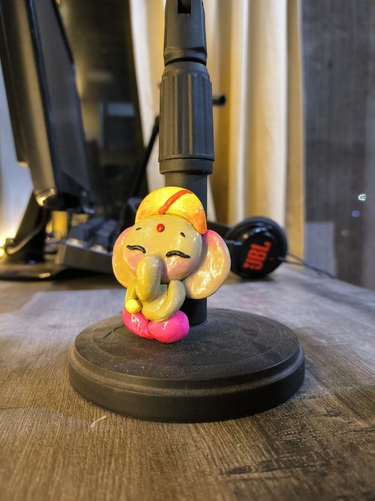 an elephant figurine sitting on top of a desk next to a computer monitor