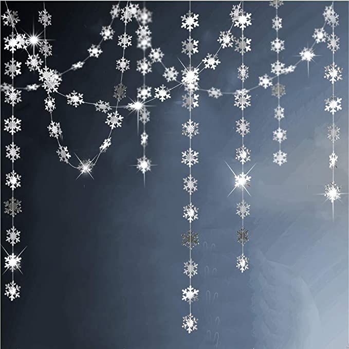 snowflakes hanging from the ceiling in front of a black background with white stars