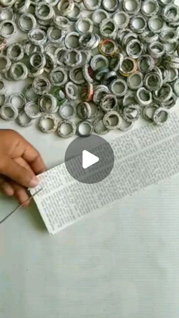 a person is making something out of rolled up newspaper rolls with scissors on the table