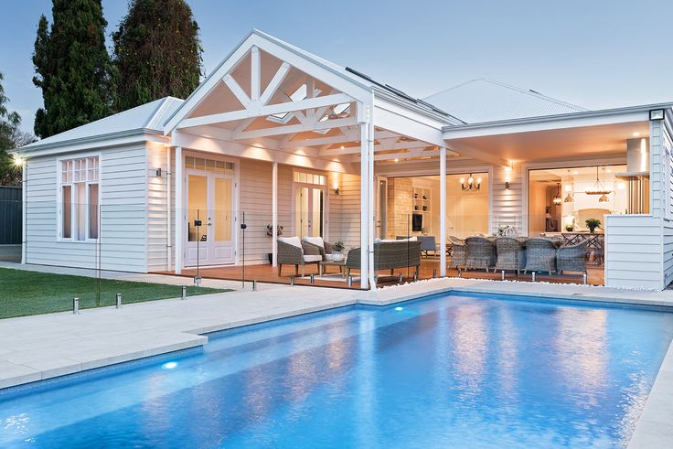 a house with a swimming pool in front of it and an outdoor living area next to it