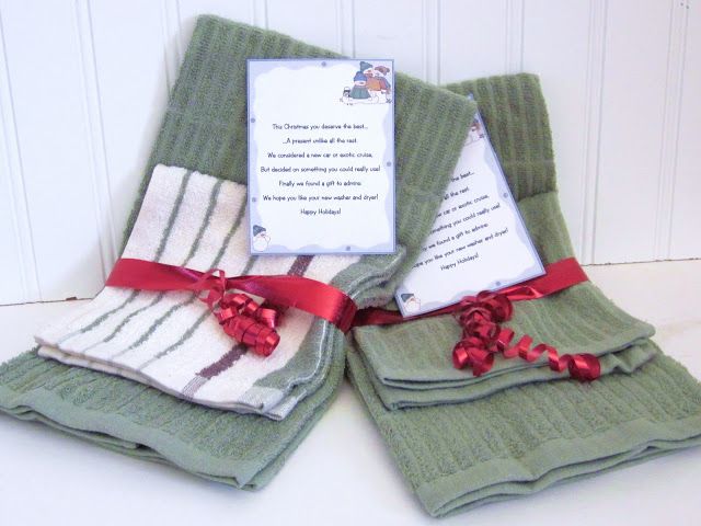 three folded green towels with red ribbon on them and a note attached to each towel