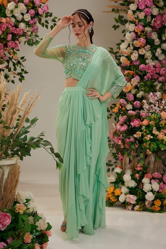 Green pre-draped ruffled saree in georgette base. Paired with a floral cutdana, sequin and pearl embroidered blouse and embellished blouse. - Aza Fashions Chiffon Blouse For Eid Party, Pre-draped Georgette Saree With Zari Work, Diwali Party Wear Georgette Pre-draped Saree, Semi-stitched Georgette Blouse Piece With Ruffles, Festive Georgette Pre-draped Saree For Eid, Chiffon Blouse Piece With Mirror Work In Traditional Drape, Eid Georgette Blouse With Sequins, Eid Sequined Georgette Blouse, Chiffon Blouse Piece With Mirror Work