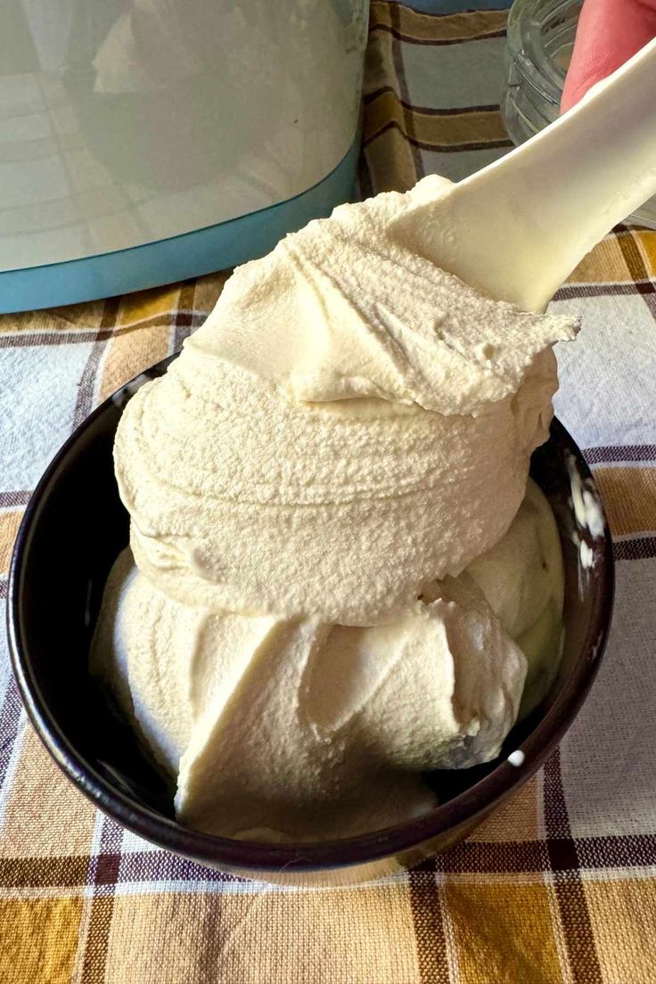 a bowl filled with ice cream sitting on top of a checkered tablecloth covered table