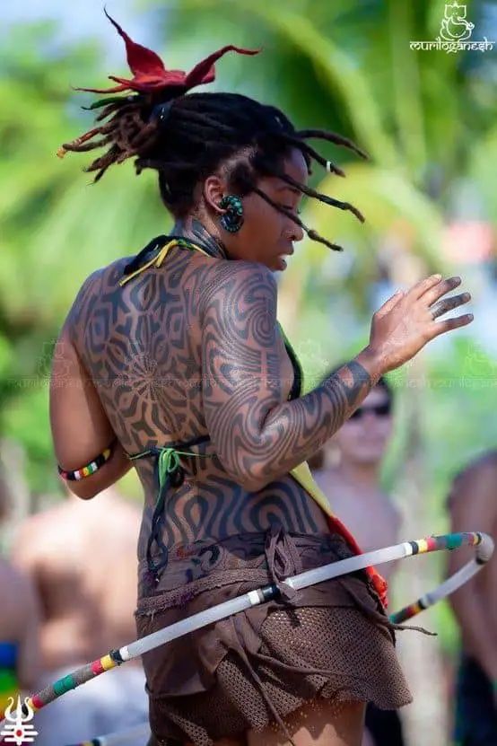 a woman with tattoos on her body holding two hula hoops in front of other people