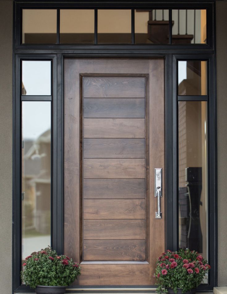 a wooden door with two planters on the side