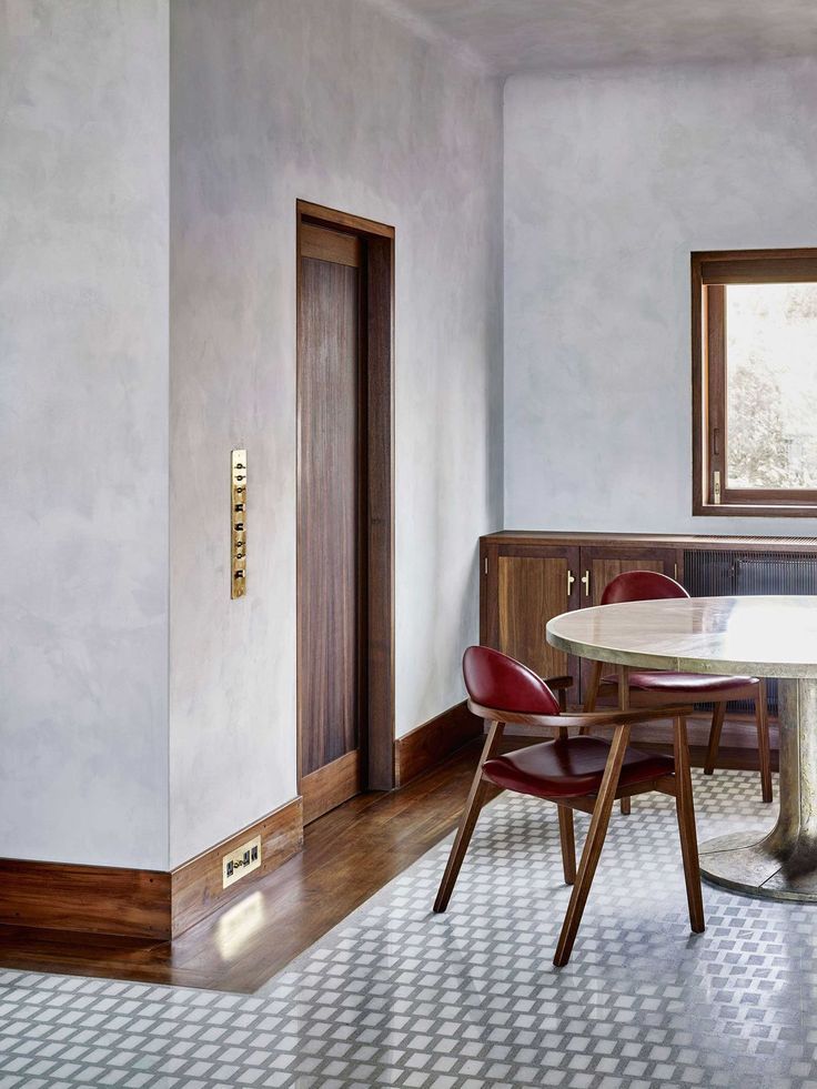 a dining room with a table and chairs next to a doorway that leads into another room