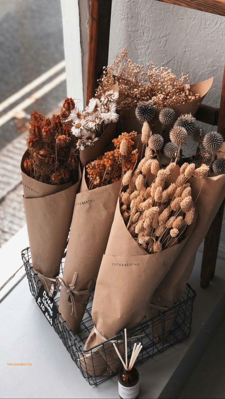 three cones filled with dried plants sitting on top of a table