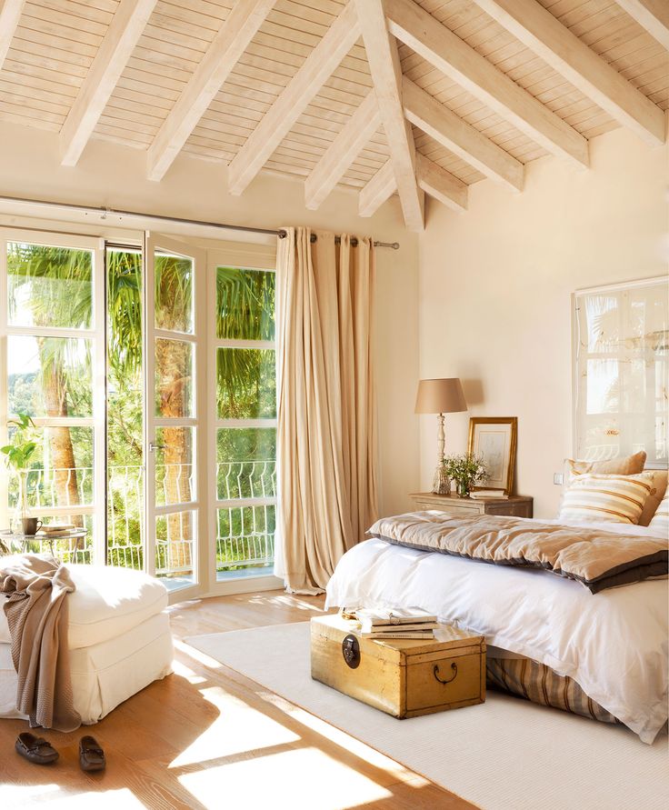 a bedroom with a bed, dresser and large window in it's center area