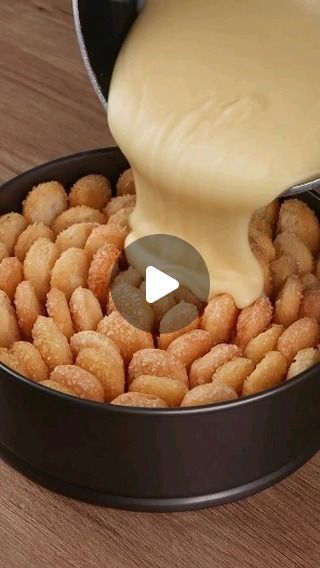 a person pouring sauce on some food in a pan