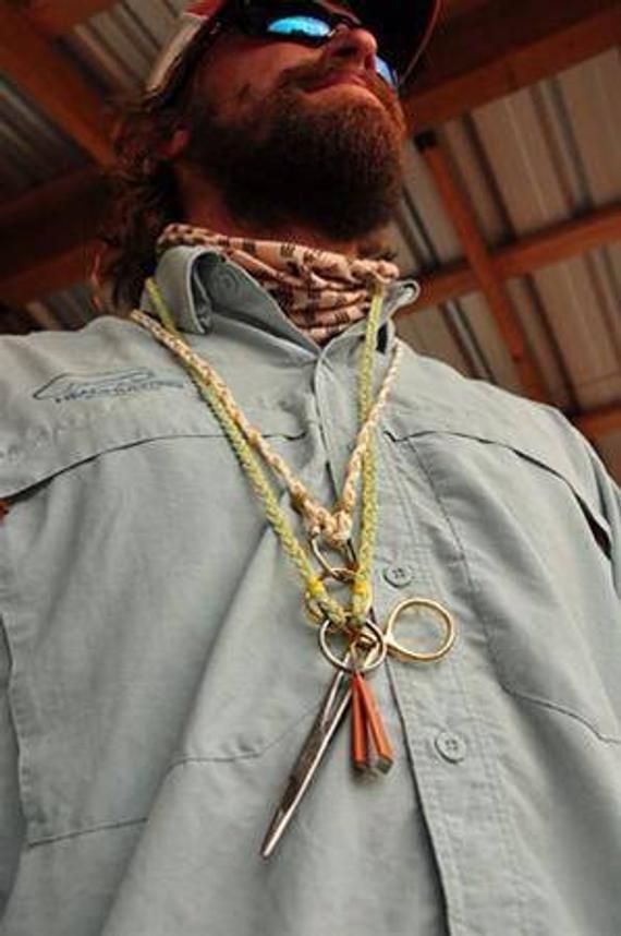 a man wearing sunglasses and a necklace with scissors hanging from it