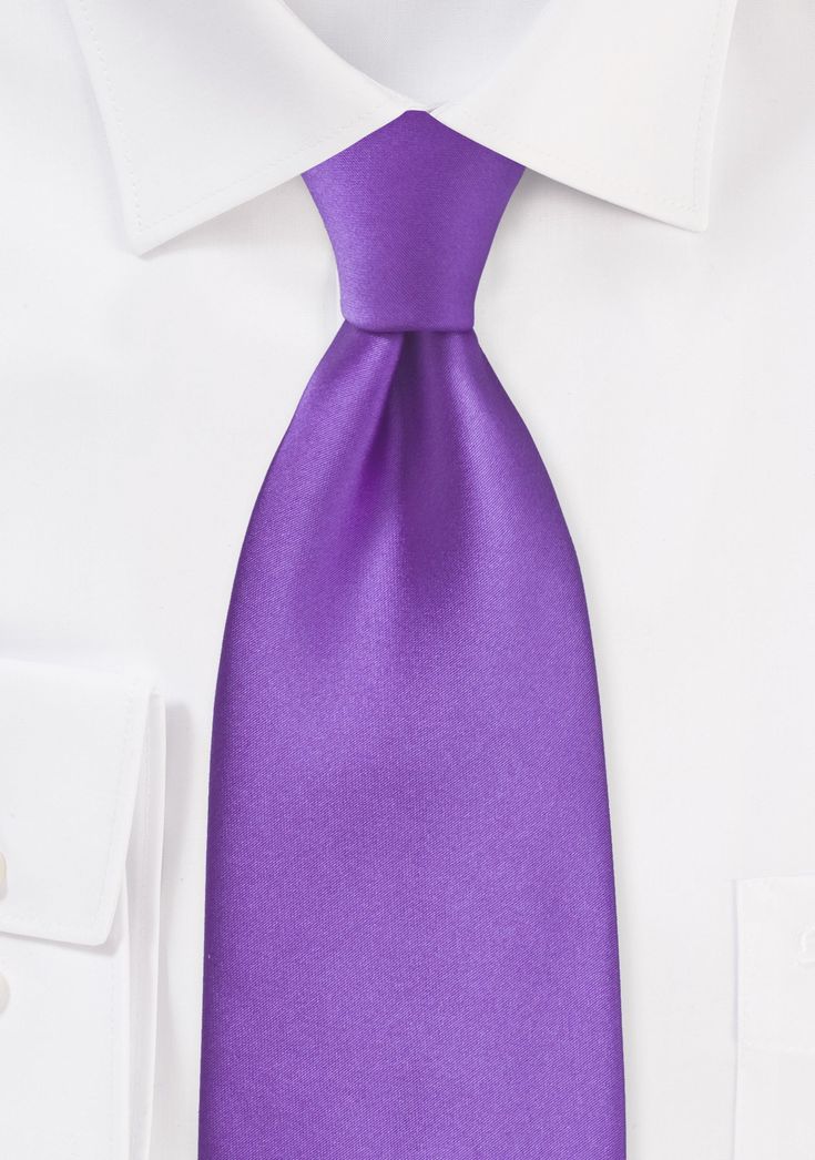 A dazzling sheen emanates from this necktie, which is a solid shade of purple. Because it is manufactured from man-made microfiber, this tie has the look and feel of one of our silk ties, but in contrast to silk, it is far more resistant to stains and wrinkles. The possibilities are endless when you match this tie to your shirt and suit. In general, the color purple is one that pairs incredibly well with various hues of blue and grey, both of which are traditional colors that are typically found Shade Of Purple, Hues Of Blue, The Color Purple, Purple Tie, Classy Dress Outfits, Blue And Grey, Men's Wardrobe, Classy Dress, Shades Of Purple