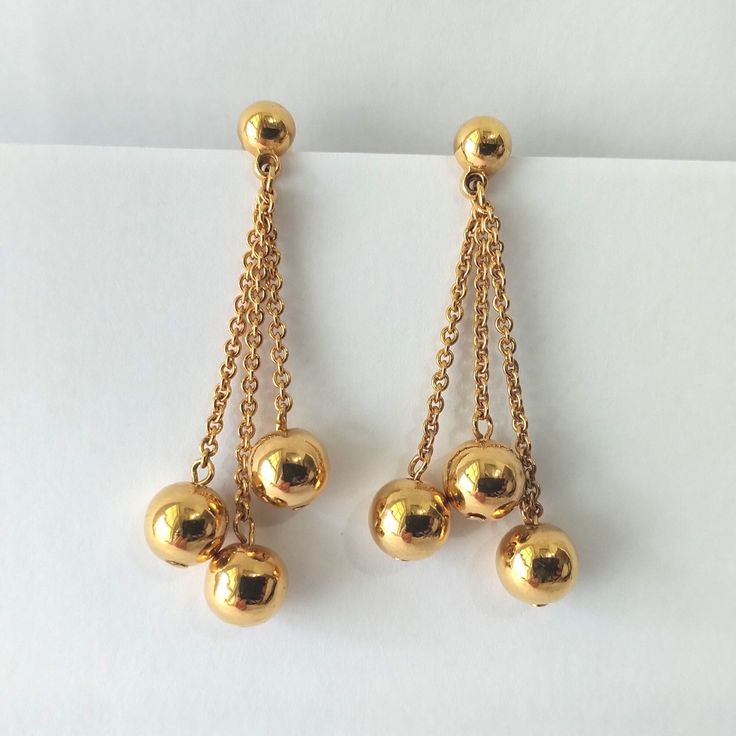 Vintage gold plated chain drop bead pierced earrings. Great condition with shiny polish. No markings. Size: 1 7/8" x 5/8"   Thank you for visiting our shop! Please refer to photos as part of the description. Please Check out FAQs and Shop Policies and our other items  on our home page at https://vintagebytiffinie.etsy.com SHIPPING: We combine shipping if your items can be packed safely together.  All purchases over $100.00 ships with signature confirmation.  Please contact us with any further qu Gold Dangle Earrings With Beaded Chain, Gold Linear Earrings With Dangling Beads For Party, Gold Beaded Long Drop Earrings, Dangle Ball Chain Jewelry, Gold-tone Dangle Chandelier Earrings, Gold Dangle Earrings With Dangling Beads, Gold Earrings With Latkans And Round Beads, Gold-plated Dangling Bead Earrings, Gold-plated Earrings With Dangling Beads