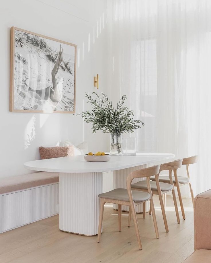 a white dining table with four chairs around it