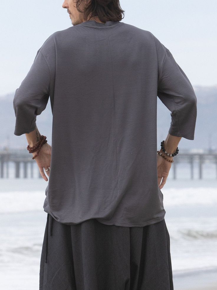 This gray loose mens top is so soft and so comfy that it will be your perfect lounge wear, as well as a great yoga shirt or a meditation top. It has a nice edgy urban look and can be worn in the city as well as a part of a festival outfit. Try it with our glorka harem pants - they go so well together! Materials: stretch cotton jersey. NOTE: If you want black or white color- please message in the notes to seller when purchasing. Fabric for this pair was bought in Fashion District in LA and the pa Gray Yoga Tops For Summer, Gray Yoga Top For Summer, Oversized Crew Neck Top For Relaxation, Gray Summer Yoga Top, Gray Summer Tops For Yoga, Comfortable Solid Color Tops For Relaxation, Comfortable Solid Tops For Yoga, Relaxed Fit Tops For Relaxation, Gray Casual Yoga Top