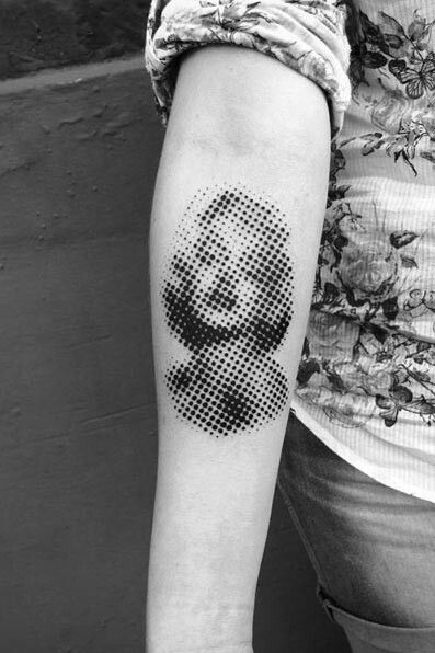 a black and white photo of a person's arm with a pixel dot tattoo on it